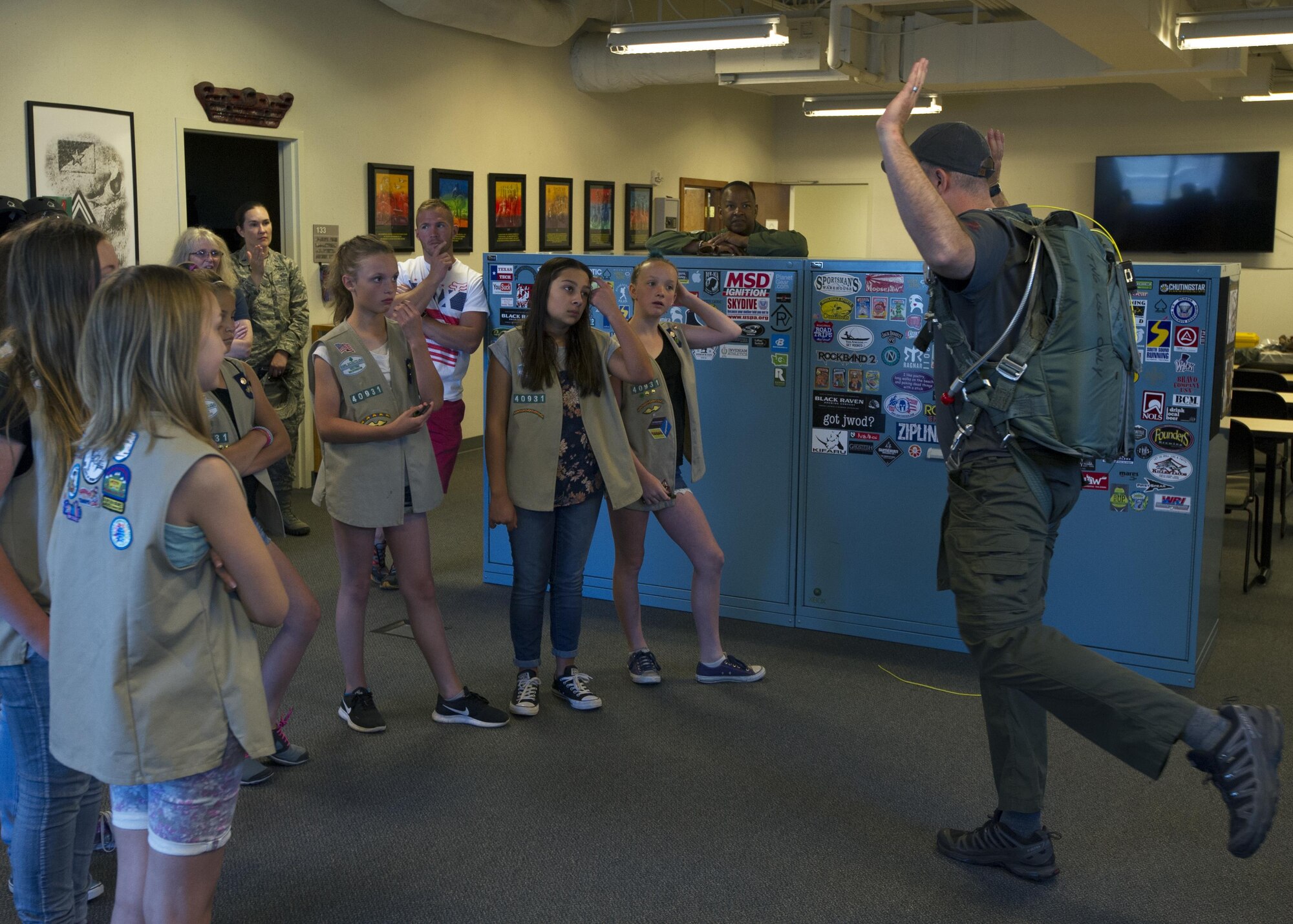 Staff Sgt. David Bowden, a Survival, Evasion, Resistance and Escape, instructor assigned to the 62nd Operations Support Squadron, discusses parachuting with several Girl Scouts July 9, 2017, at McChord Field. During the visit, seven girl scouts were able to tour the 446th AW, a C-17, control tower, and learned SERE survival tips. (U.S. Air Force photo by Tech. Sgt. Bryan Hull)