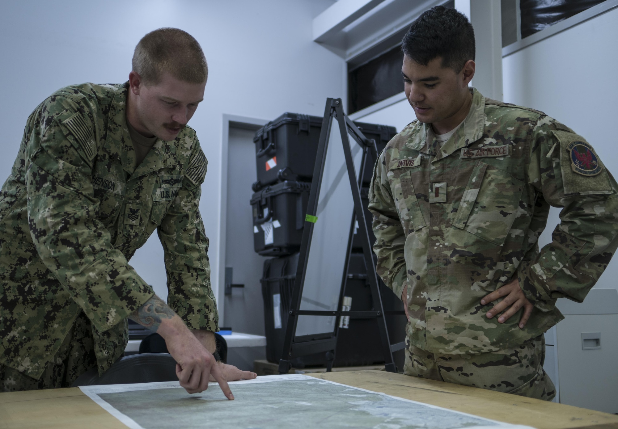 A U.S. Navy Helicopter Sea Combat Squadron-85 intelligence analyst points out locations on a map of Central Queensland in Australia to a U.S. Air Force 1st Special Operations Squadron intelligence officer, as the analysts build the intelligence picture for the warfighting scenario of Talisman Saber 2017, July 10, 2017 at Rockhampton, Australia. Aside from service components working with the Australian military, the exercise also provided an opportunity for U.S. forces to integrate intelligence systems and share tactics, trainings and procedures with other U.S. services. (U.S. Air Force photo by Capt. Jessica Tait)