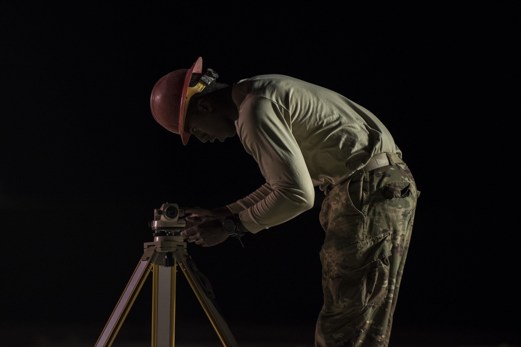 Staff Sgt. Jackie Timmons, 557th Expeditionary RED HORSE structural craftsman, adjusts a laser level to ensure construction is started on the proper elevation June 27, 2017, in Southwest Asia. The squadron provides engineering services throughout the Air Force Central Command area of responsibility, inside and outside the wire. (U.S. Air Force photo/Senior Airman Damon Kasberg)