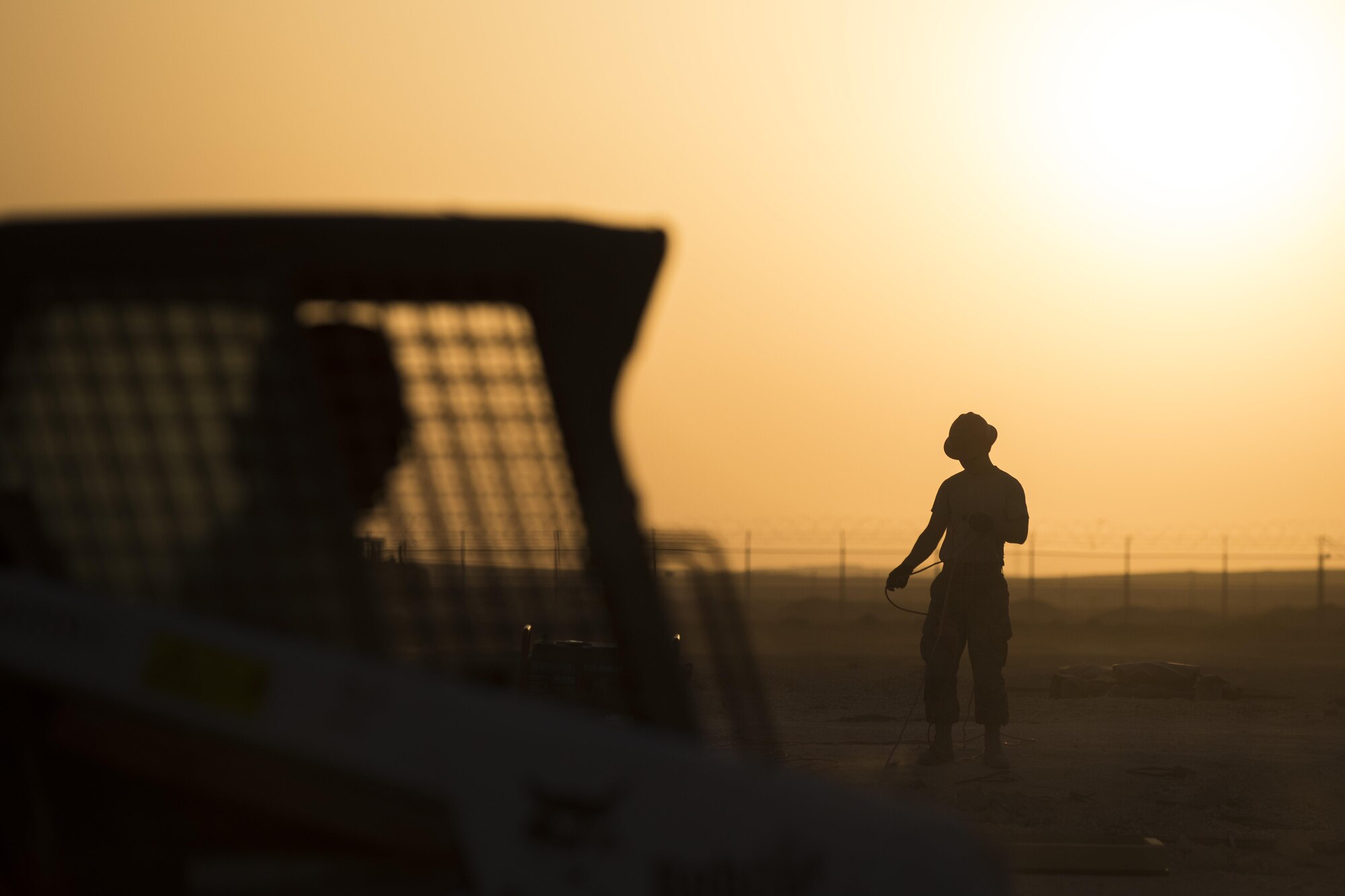 An Airman assigned to the 557th Expeditionary RED HORSE, wraps a cord to move construction equipment June 27, 2017, in Southwest Asia. The squadron provides engineering services throughout the Air Force Central Command area of responsibility, inside and outside the wire. (U.S. Air Force photo/Senior Airman Damon Kasberg)