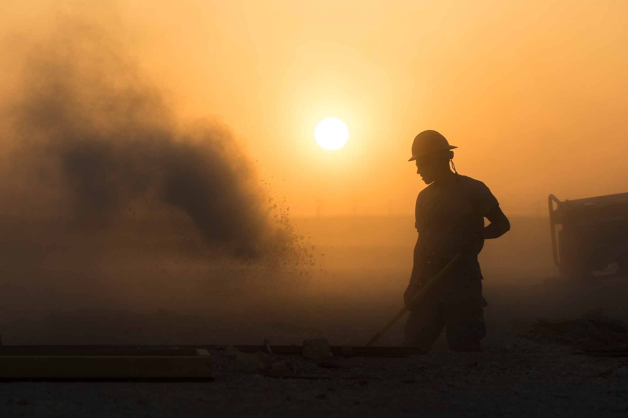 Staff Sgt Dominic Koah, 557th Expeditionary RED HORSE water fuels system maintenance craftsman, shovels dirt and concrete away from a construction site June 27, 2017, in Southwest Asia. Working through extreme heat and high winds members of RED HORSE construct pre-engineered buildings vital to the expansion of the 332nd Air Expeditionary Wing and its operational capabilities. (U.S. Air Force photo/Senior Airman Damon Kasberg)