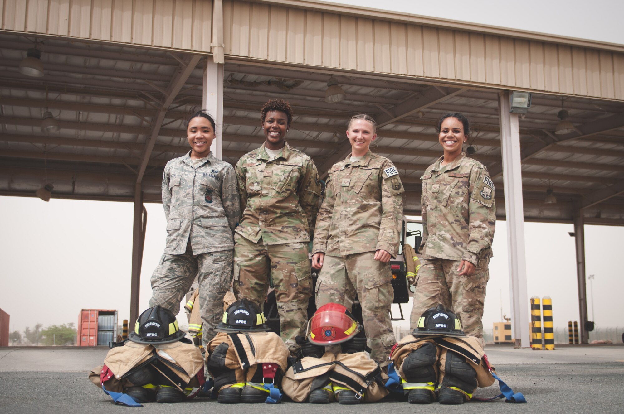 From left to right, Senior Airman Ayanna Gaskin, Senior Airman Christa Dennis, Senior AirmanAshley Eisenbarth, and Staff Sgt. Jessica Mendoza, fire fighters assigned to the 386th Civil Engineer Squadron, pose for a photo Sunday, June 25, 2017, in front of a fire truck in the parking bay ata 386th Air Expeditionary Wing fire station at an undisclosed location in Southwest Asia. (U.S. Air Force photo by Master Sgt. Eric M. Sharman)