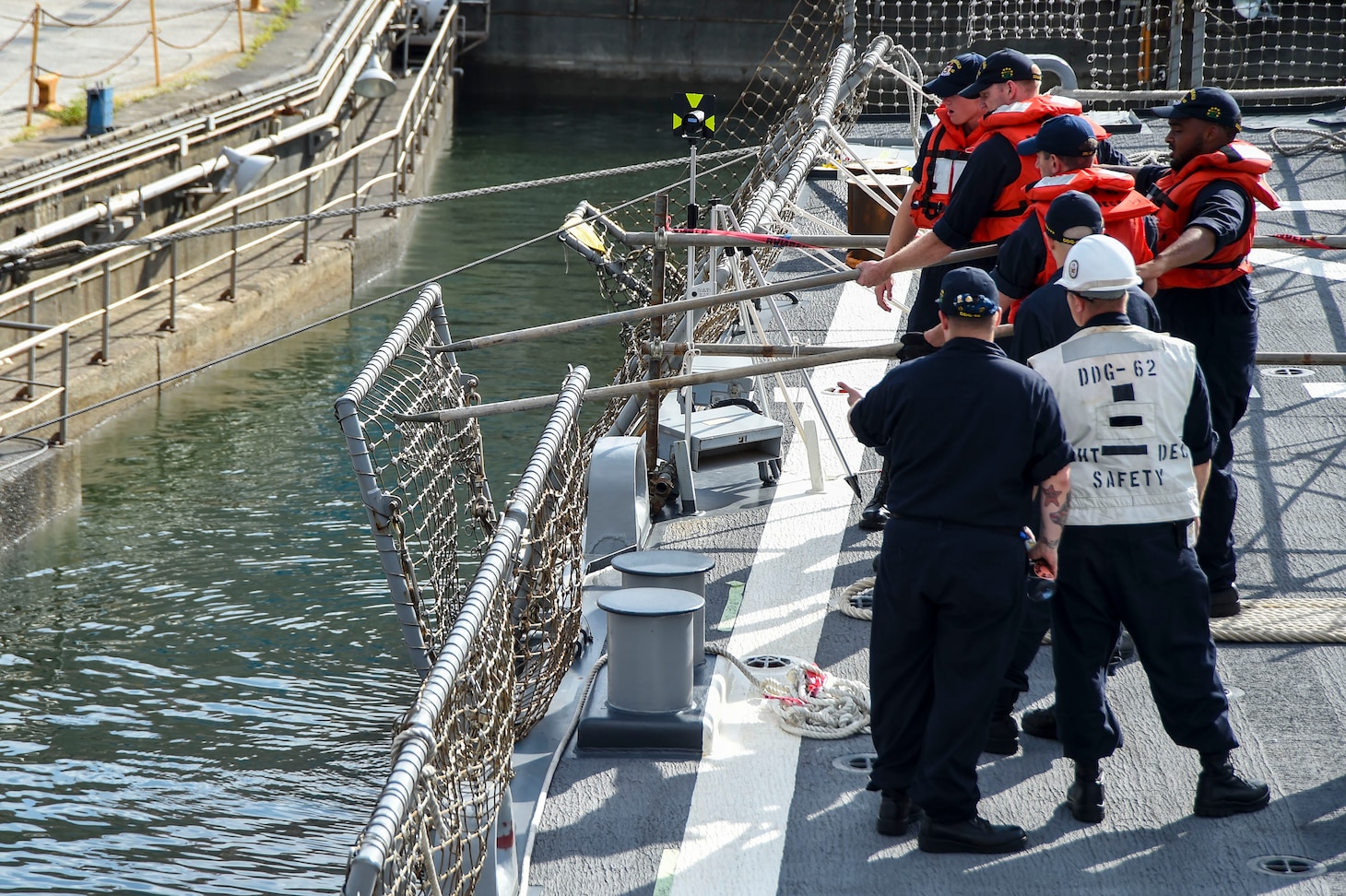 YOKOSUKA, Japan (July 11, 2017) Sailors assigned to Arleigh Burke-class guided-missile destroyer USS Fitzgerald (DDG 62) lowerflight deck safety nets during the ship's transition into Dry Dock 4 at Fleet Activities (FLEACT) Yokosuka. Fitzgerald is entering dry dock at FLEACT Yokosuka to continue repairs and assess damage sustained from its June 17 collision with a merchant vessel. 