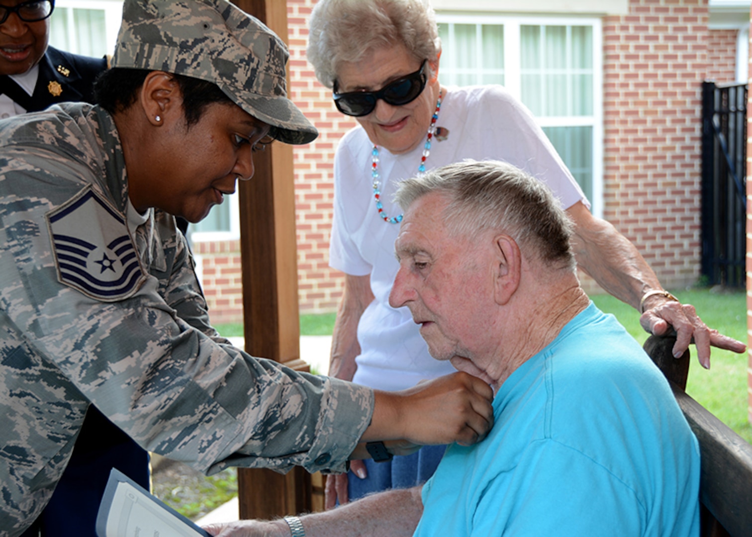 Air Force Master Sgt. Nikki Broomfield, military human resources specialist, Resource Management Division, Command Support Directorate, DLA Aviation, attaches a pin to Henry Pleasants, a World War II veteran who suffers from Alzheimer’s, after an Independence Day ceremony to honor veterans at the Dunlop Home assisted living facility, in Colonial Heights, Virginia July 6, 2017.
