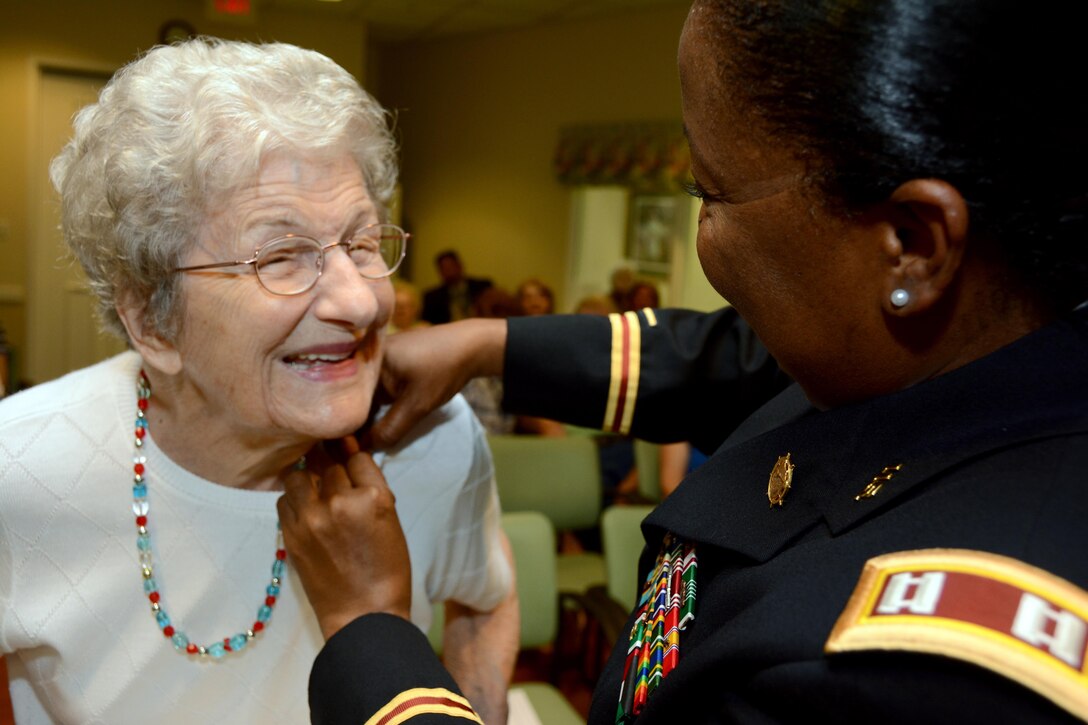 Army Capt. Constance Marable, Advance Individual Training Tango Company commander, 266th Quartermaster Battalion, Fort Lee, Virginia, attaches a pin to Laura Pleasants in her husband’s absence during an Independence Day ceremony to honor veterans at the Dunlop House, an assisted living facility, July 6, 2017. Her husband, Henry Pleasants, was unable to attend the ceremony as he was in the memory assisted area of the Dunlop House, in Colonial Heights, Virginia.