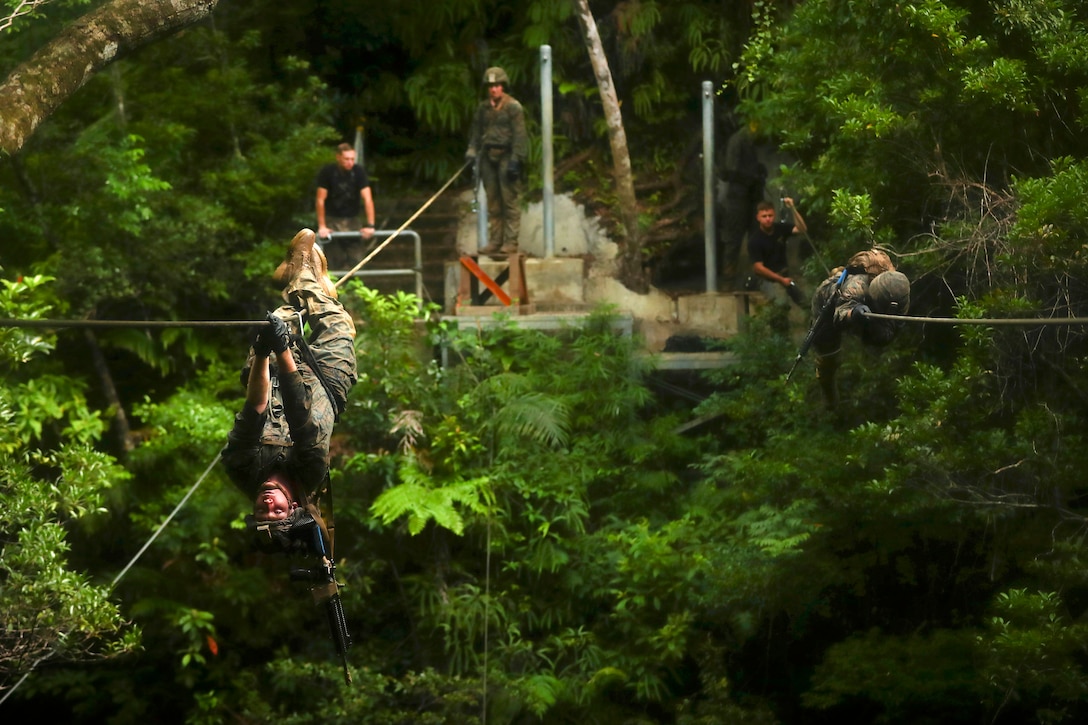 Marines move upside down along a rope obstacle during an endurance course at the Jungle Warfare Training Center at Camp Gonsalves in Okinawa, Japan, July 7, 2017. Marine Corps photo by Cpl. Aaron S. Patterson