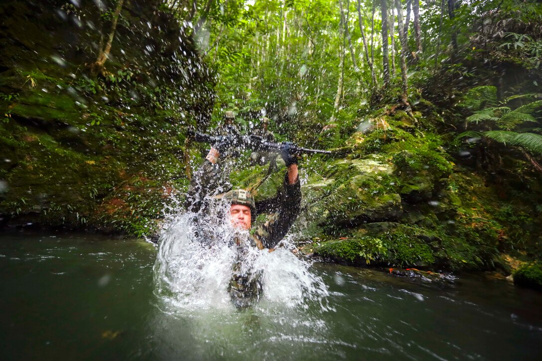 Marine Corps Lance Cpl. Kanta C. Covey jumps into a river during an endurance course at the Jungle Warfare Training Center at Camp Gonsalves in Okinawa, Japan, July 7, 2017. Covey is a mortarman assigned to Bravo Company, 1st Battalion, 3rd Marine Regiment. Marine Corps photo by Cpl. Aaron S. Patterson