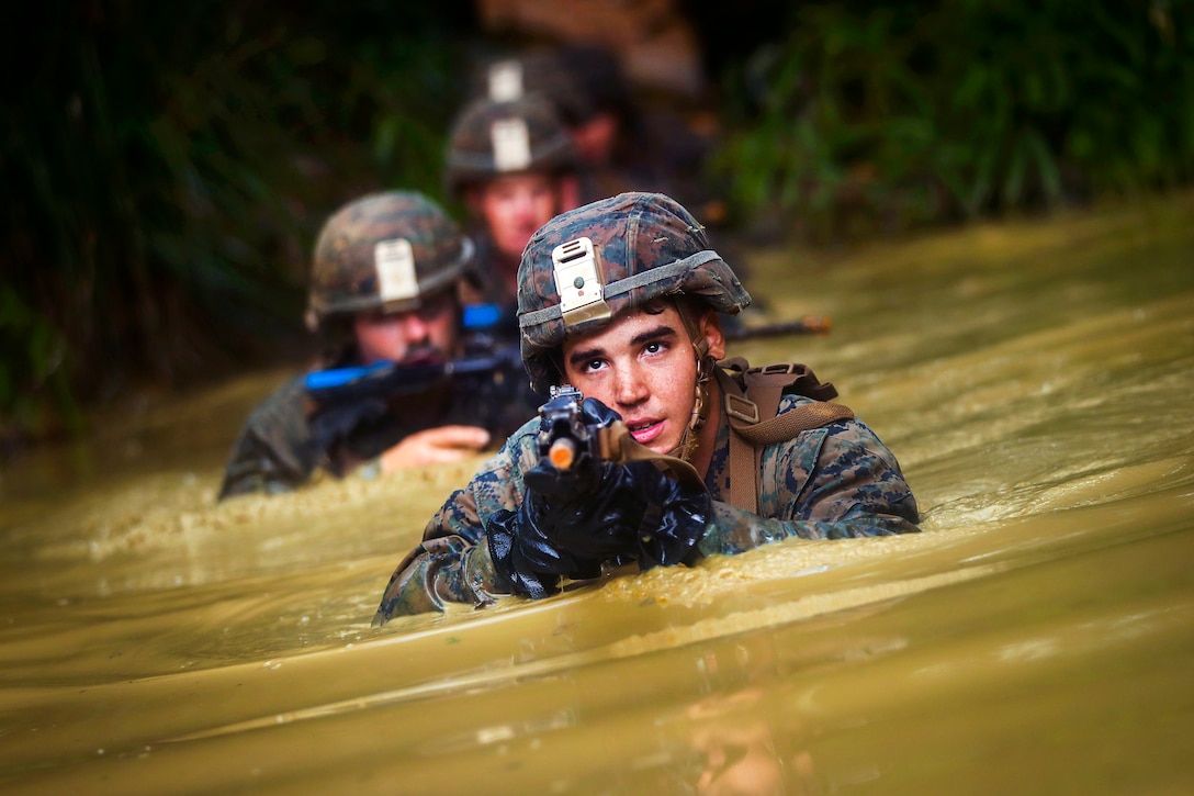 Marine Corps Cpl. Bryan Hernandezrodriguez maneuvers through the 'Pit and Pond' obstacle during an endurance course at the Jungle Warfare Training Center at Camp Gonsalves in Okinawa, Japan, July 7, 2017. Hernandezrodriguez is a rifleman assigned to Bravo Company, 1st Battalion, 3rd Marine Regiment. Marine Corps photo by Cpl. Aaron S. Patterson