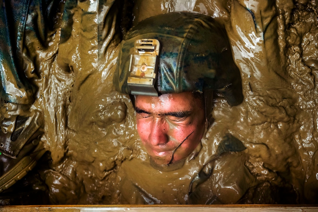 A Marine is dragged from underneath a booby trap at the 'Pit and Pond' obstacle during an endurance course at the Jungle Warfare Training Center at Camp Gonsalves in Okinawa, Japan, July 7, 2017. Marine Corps photo by Cpl. Aaron S. Patterson