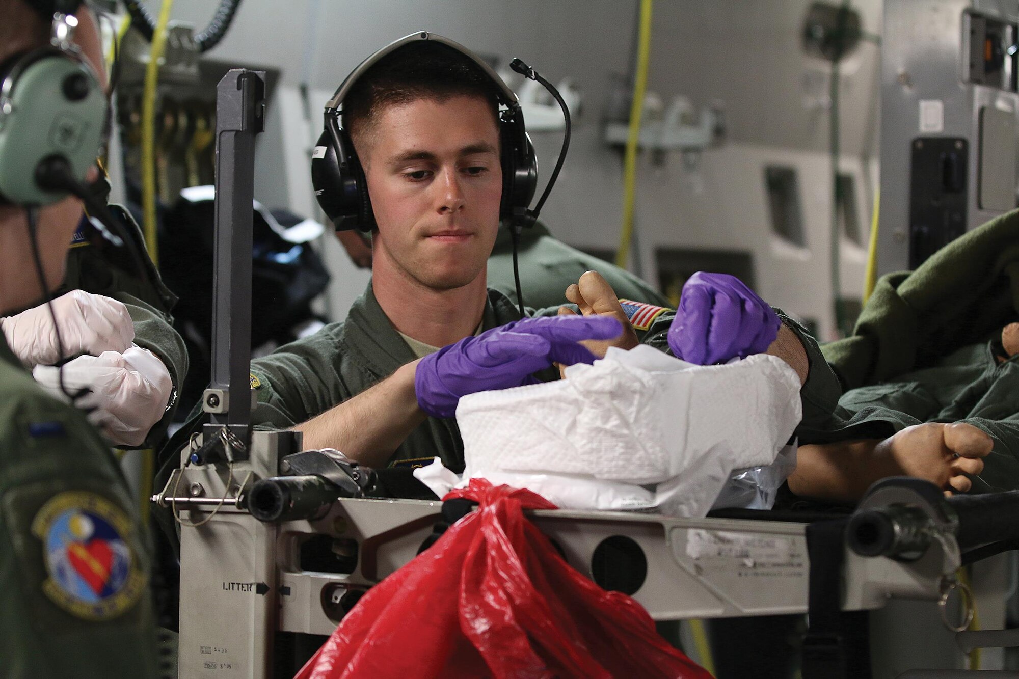 Senior Airman Tyler Frisby, 445th Aeromedical Evacuation Squadron AE technician, attends to a “patient” while other AE Airmen watch and learn as part of their training on board a 445th Airlift Wing Globemaster III June 20, 2017. AES Airmen engaged in various patient emergency scenarios during the training flight. (U.S. Air Force photo/Tech. Sgt. Patrick O’Reilly)