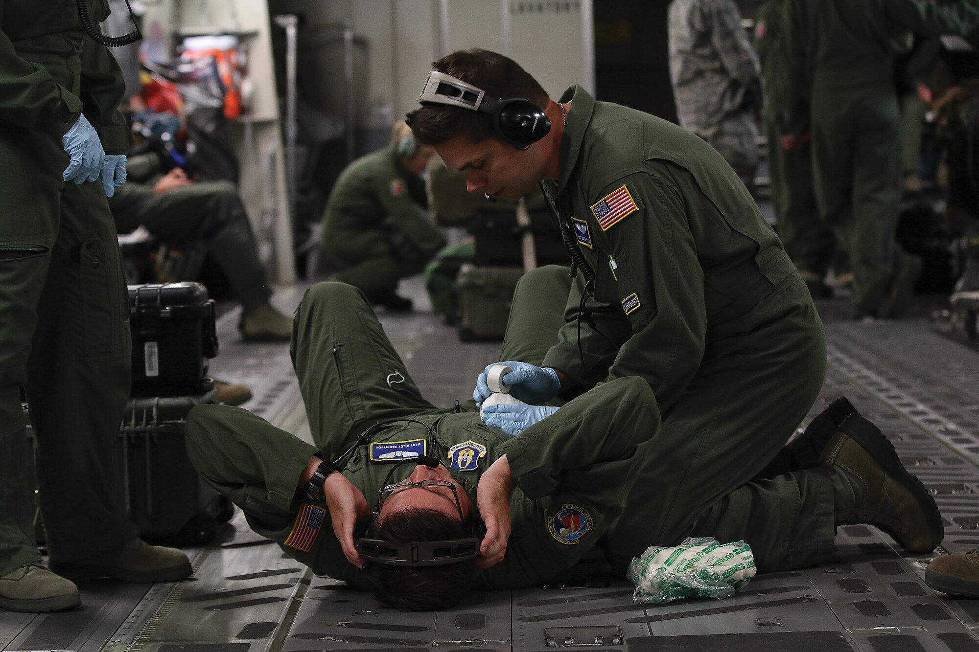 Tech. Sgt. Justin Staten, 445th Aeromedical Evacuation Squadron medical technician treats fellow AES medical technician Master Sgt. Kiley Gerritsen for a simulated wound. AES Airmen engaged in various patient emergency scenarios as part of their training during a flight onboard a 445th Airlift Wing C-17 Globemaster III June 20, 2017. (U.S. Air Force photo/Tech. Sgt. Patrick O’Reilly)