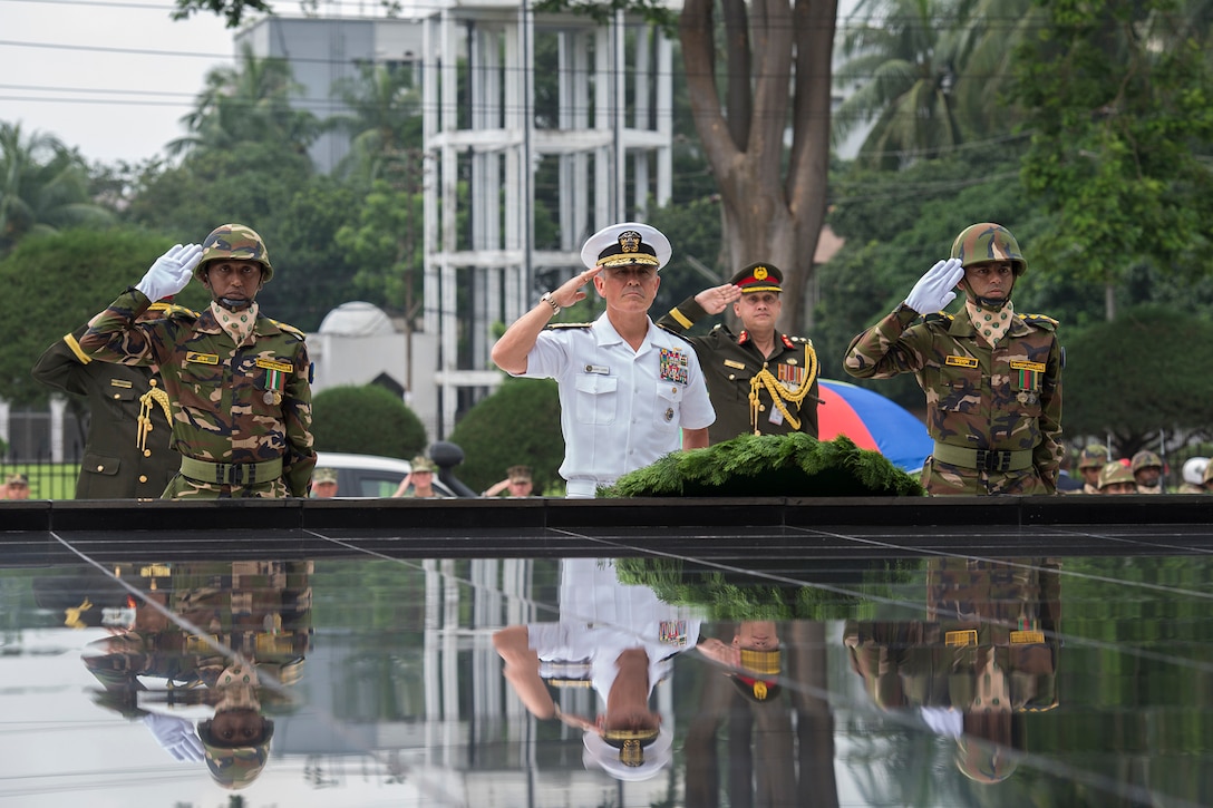 Navy Adm. Harry Harris, commander of U.S. Pacific Command, and Bangladeshi soldiers salute during a wreath-laying ceremony at the Shikha Anirban, or eternal flame, in Dhaka, Bangladesh, July 8, 2017, to honor those who sacrificed their lives for Bangladesh’s liberation in 1971. Navy photo by Petty Officer 2nd Class Robin W. Peak