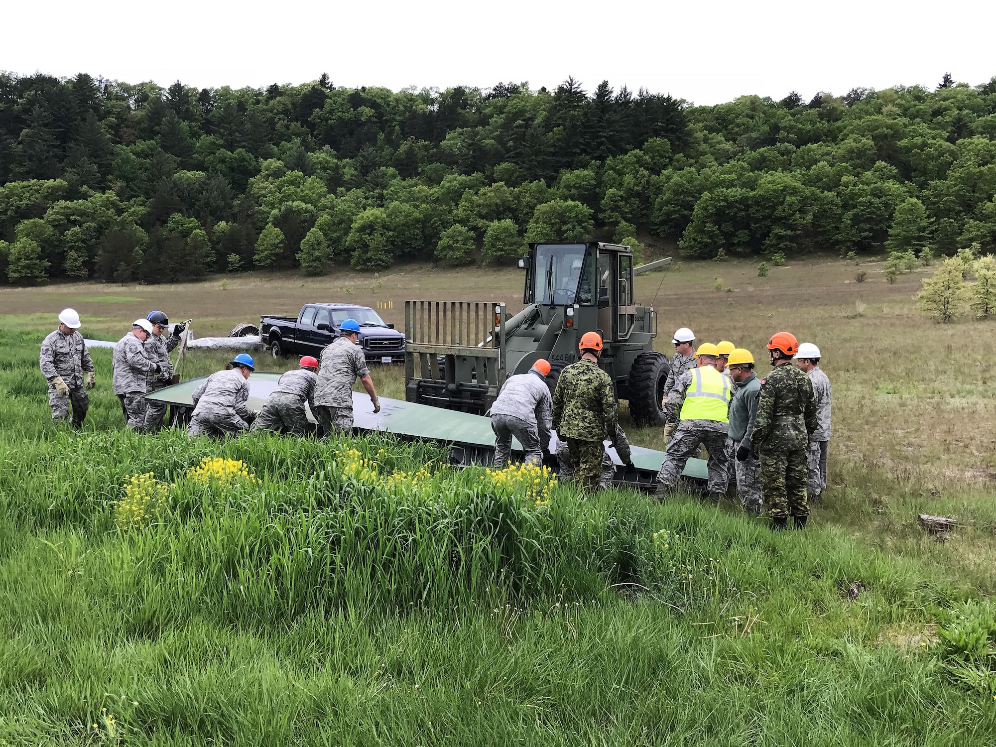 Students taking part in a Crash Damage or Disabled Aircraft Recovery (CDDAR) training course at Volk Field Air National Guard base on May 23, work together to pick up a wing of an aircraft that was found at a simulated crash site. The students are required to properly catalogue all the debris and individually create crash recovery plans as part of their training. As well as mitigating any further environmental impact from the incident. Wisconsin National Guard photo by Maj. Penny Ripperger