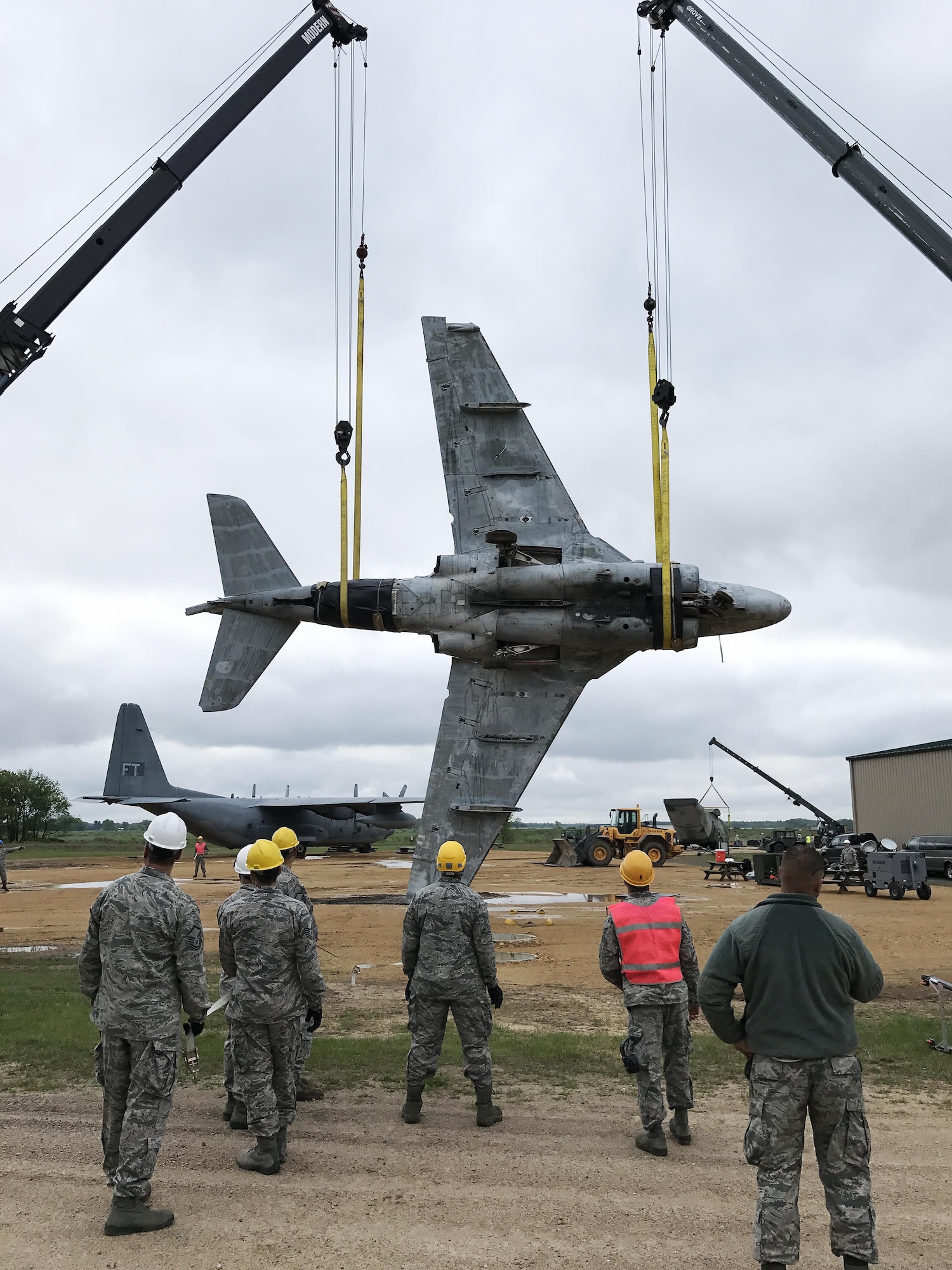 Students lift a 21,000 pound decommissioned A-6E Intruder Navy plane during a Crash Damage or Disabled Aircraft Recovery (CDDAR) training course at Volk Field Air National Guard base on May 23. In the simulation, the aircraft was found upside down and students must rig the aircraft and conduct a complex lift and roll maneuver. During the procedure, the appointed team chief, who is also a student in the class, coordinates the task with the two crane operators. Wisconsin National Guard photo by Maj. Penny Ripperger