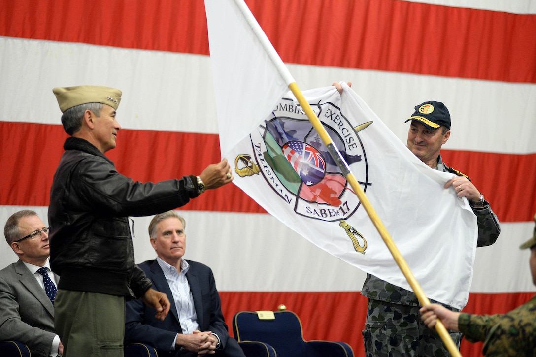 Navy Adm. Harry B. Harris, commander of U.S. Pacific Command, left, and Royal Australian Navy Vice Adm. David Johnston, chief of joint operations, unfurl the ceremonial Talisman Saber 2017 flag during the Talisman Saber 2017 opening ceremony aboard the amphibious assault ship USS Bonhomme Richard, June 29, 2017. Navy photo by Petty Officer 2nd Class Sarah Villegas