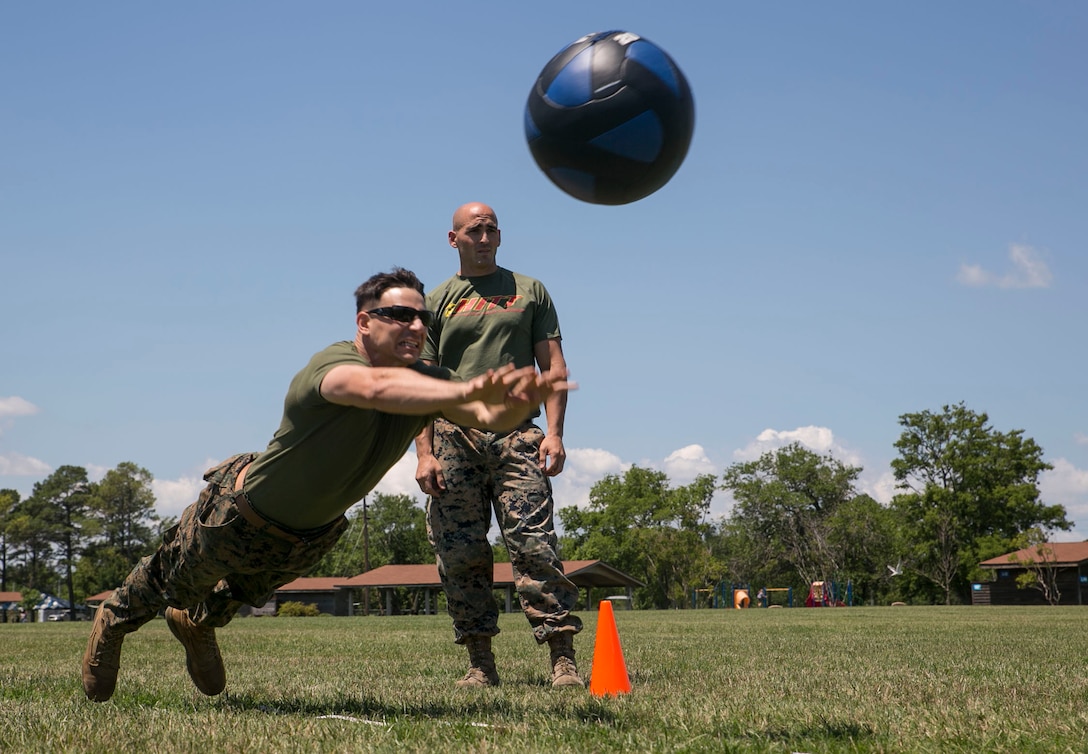 Capt. Samuel Modica, company commander, Headquarters and Service Co., Marine Corps Security Force Regiment, launches a medicine ball during the kneeling powerball throw event of the High Intensity Tactical Training preliminary competition at Captain Slade Cutter Park, Norfolk, Va., June 28. The competition is an annual event in which Marines compete in their area for a shot at competing in San Diego at the national competition.(Official U.S. Marine Corps photo by Cpl. Logan Snyder/ Released)