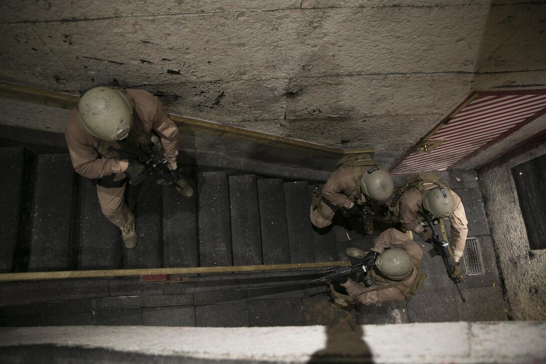 Close Quarters Battle instructors with Training Co., Marine Corps Security Force Regiment, work as a four-man team to clear a building during Instructor Progression Training, June 23, aboard Naval Support Activity Northwest Annex, Chesapeake, Va. After completion of this quarterly training, instructors were refreshed on the skills and knowledge of the concepts of close-quarters battle and interior tactics in order to confidently instruct the next course. (U.S. Marine Corps photo by Sgt. Kayla D. Rivera/Released)