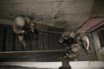 Close Quarters Battle instructors with Training Co., Marine Corps Security Force Regiment, work as a four-man team to clear a building during Instructor Progression Training, June 23, aboard Naval Support Activity Northwest Annex, Chesapeake, Va. After completion of this quarterly training, instructors were refreshed on the skills and knowledge of the concepts of close-quarters battle and interior tactics in order to confidently instruct the next course. (U.S. Marine Corps photo by Sgt. Kayla D. Rivera/Released)