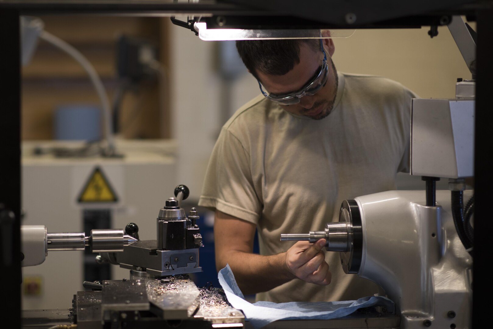 Airman 1st Class Christopher Brown, 27th Maintenance Squadron Aircraft Metals Technology apprentice, fits a piece of metal into a precision lathe at Cannon Air Force Base, New Mexico, June 21, 2017. The tolerances for the lathe that Brown is working on can be a thousandths of an inch or more. (U.S. Air Force photo by Staff Sgt. Michael Washburn/Released)