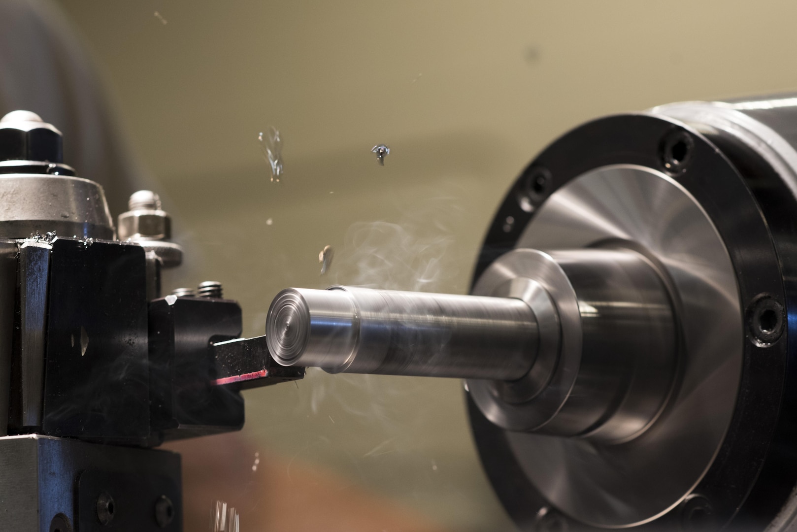 Shavings fly off a metal rod in a lathe at the 27th Special Operations Maintenance Squadron Metals Technology shop at Cannon Air Force Base, New Mexico, June 21, 2017. The tolerances for the lathe that Brown is working on can be a thousandths of an inch or more. (U.S. Air Force photo by Staff Sgt. Michael Washburn/Released)