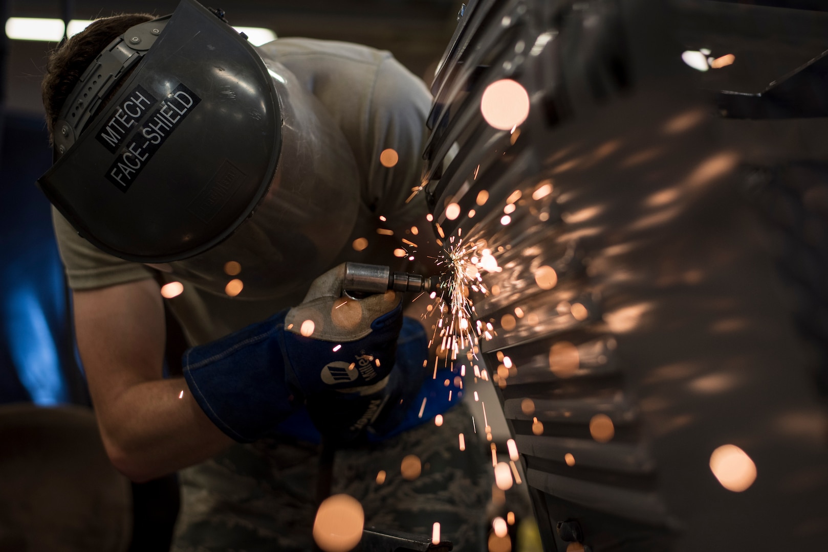 Airman 1st Class Patrick Ragan, 27th Maintenance Squadron Aircraft Metals Technology apprentice, grinds down a low-pac cover at Cannon Air Force Base, New Mexico, June 21, 2017. The cover had hair-line cracks that first needed to be filled before they were smoothed out with the grinder. (U.S. Air Force photo by Staff Sgt. Michael Washburn/Released)
