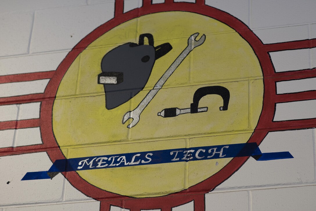 A metals tech logo is painted on the wall of the 27th Maintenance Squadron Aircraft Metals Technology shop at Cannon Air Force Base, New Mexico, June 21, 2017. The metals tech shop can fix or fabricate any piece of equipment for any of the aircraft platforms on base. (U.S. Air Force photo by Staff Sgt. Michael Washburn/Released)