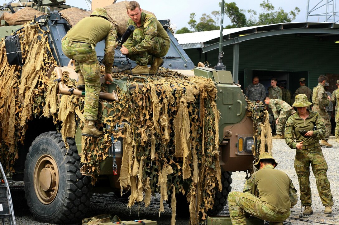 Australian soldiers attach equipment to a protected mobility vehicle while preparing for exercise Talisman Saber at the Shoalwater Bay training area in Queensland, Australia, July 10, 2017. Army National Guard photo by Sgt. Alexander Rector