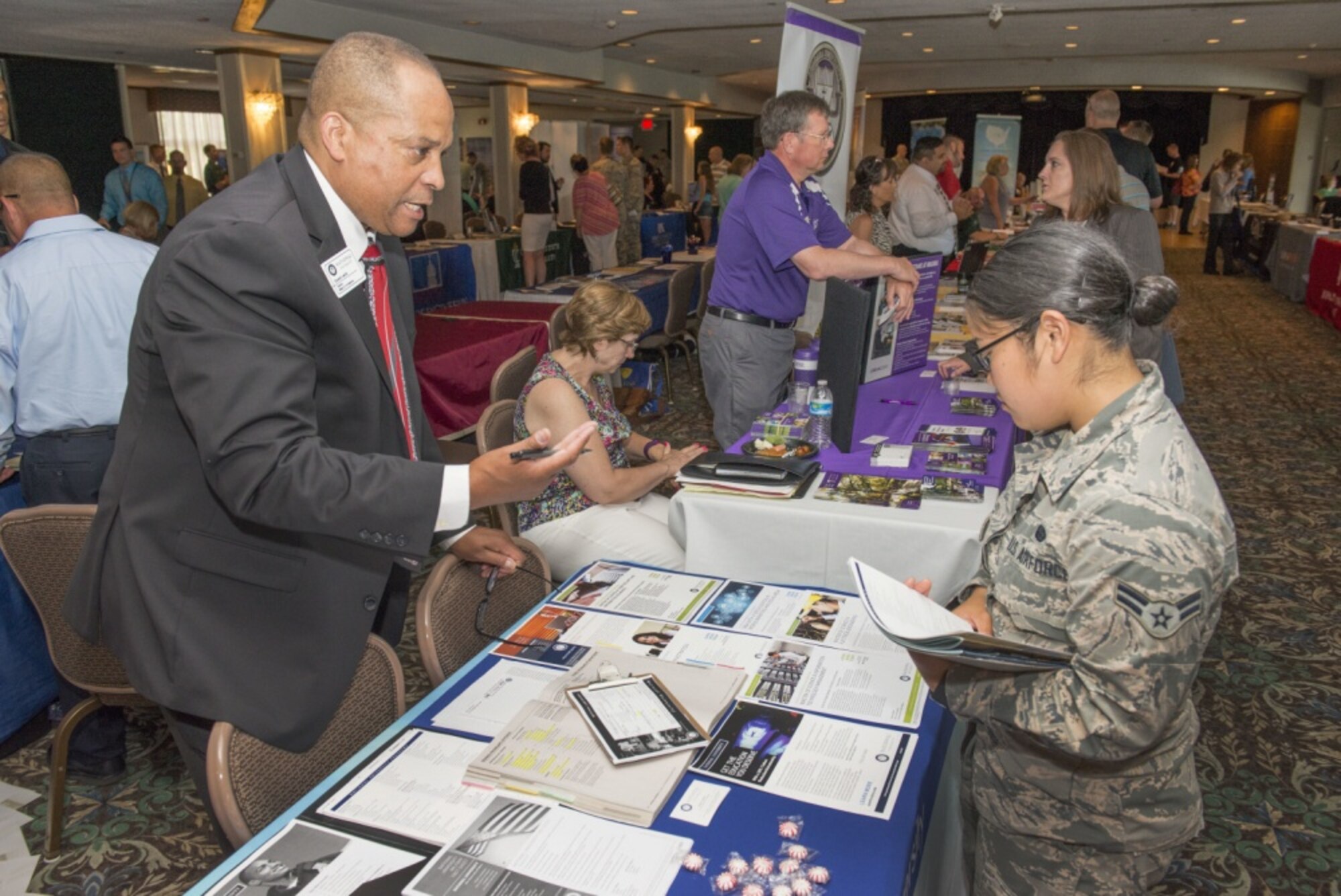 Caption: Eduardo Leardo III, Director, Military and VA Relations for National University speaks to Airman 1st Class Odessa Quezon, Systems Control Technician at the 2016 Development, Education & Training Expo. The expo is open for anyone with base access interested in education and training opportunities. (U.S. Air Force/Michelle Gigante)

