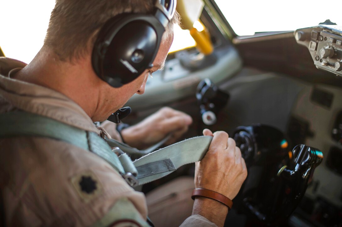An Air Force pilot straps on a safety belt before a flight supporting Operation Inherent Resolve in an undisclosed location, July 6, 2017. Air Force photo by Staff Sgt. Trevor T. McBride