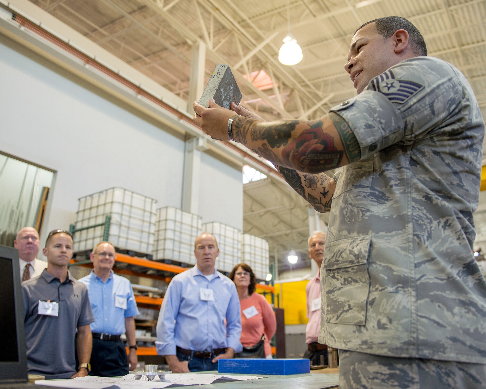 U.S. Air Force Tech. Sgt. Dominic Durgin-Rodriguez, 60th Maintenance Squadron, gives honorary commanders from Travis Air Force Base, Calif., a briefing during their tour at the base, July 7, 2017. The purpose of the Honorary Commander Program is to promote relationships between base senior leadership and civilian partners, foster civic appreciation of the Air Force mission and its Airmen, maximize opportunities to share the Air Force story with new stewards, and to communicate the mutual interests, challenges, and concerns that senior leaders and civilian stakeholders have in common. (U.S. Air Force photo by Louis Briscese)