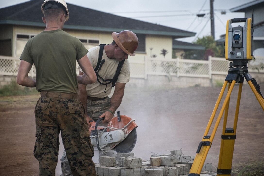 Air National Guard Tech. Sgt. John Walker works with Marine Corps Lance Cpl. Tristan Zurfluh during Innovative Readiness Training in Kapaa, Hawaii., July 10, 2017. Air National Guard photo by 1st Lt. Paul Stennett