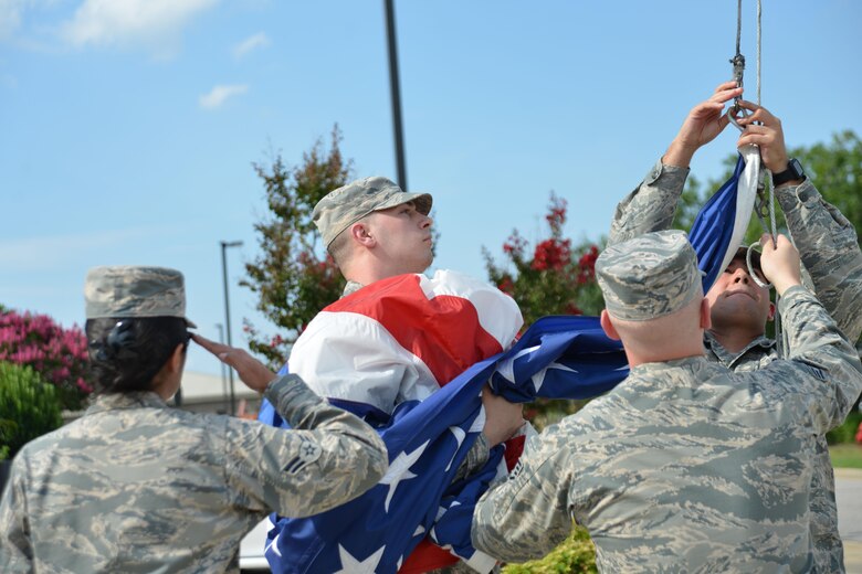 U.S. Airmen assigned to the 20th Fighter Wing (FW) detach a flag from its halyard during a retreat ceremony at Shaw Air Force Base, S.C., June 29, 2017. For the first time in 10 years, Shaw squadrons are rotating responsibility for a monthly retreat ceremony at the 20th FW headquarters. (U.S. Air Force photo by Airman 1st Class Destinee Sweeney)