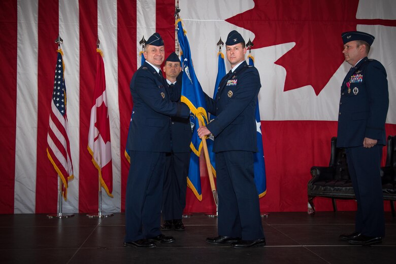 PETERSON AIR FORCE BASE, Colo. – Lt. Gen. David J. Buck, 14th Air Force and Joint Functional Component Command for Space commander, passes the 21st Space Wing guidon to Col. Todd Moore, incoming commander, during the 21st SW change of command ceremony in hangar 140, Peterson Air Force Base, Colo., July 11, 2017. Before taking command of the wing, Moore was Air Force Element commander at Royal Air Force Menwith Hill. (U.S. Air Force photo by Senior Airman Dennis Hoffman)