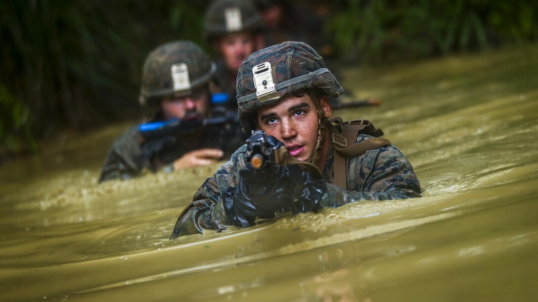 Marine Cpl. Bryan Hernandezrodriguez travels through the “pit and pond” obstacle during the endurance course at Camp Gonzales, Okinawa, Japan, July 7, 2017. Marine Corps photo by Cpl. Aaron S. Patterson