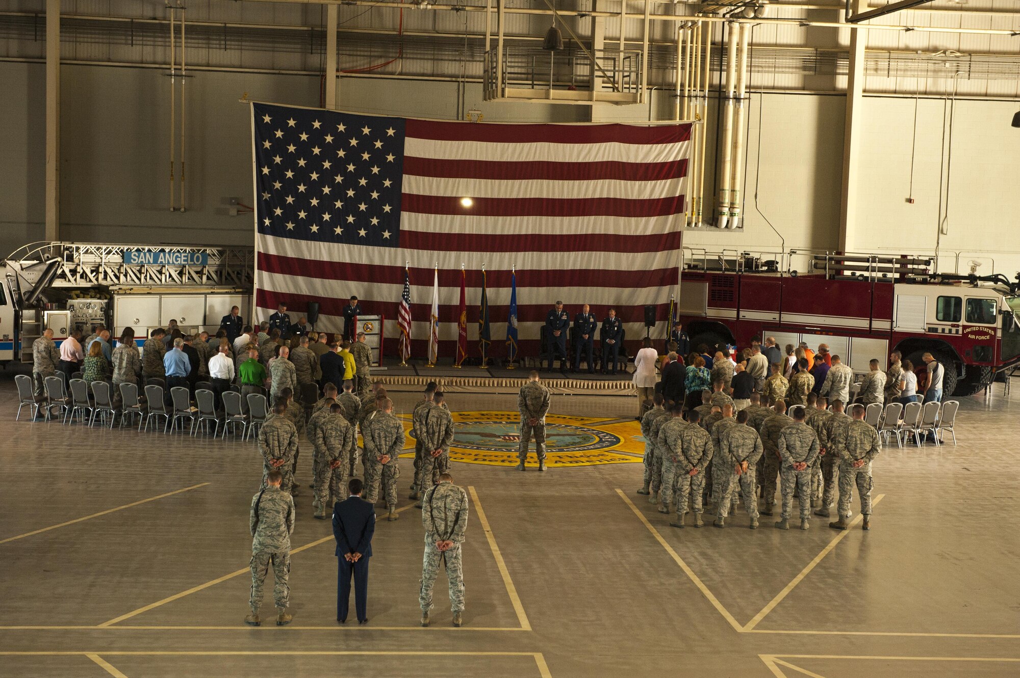 The 312th Training Squadron and visitors stand for the singing of the National Anthem during the 312th TRS change of command ceremony at the Louis F. Garland Department of Defense Fire Academy High Bay Fire Academy high bay on Goodfellow Air Force Base, Texas, July 10, 2017. The ceremony bid farewell to the previous commander, Lt. Col. Matthew Welling and welcomed the new commander, Lt. Col. Scott D. Cline. (U.S. Air Force photo by Senior Airman Scott Jackson/Released)