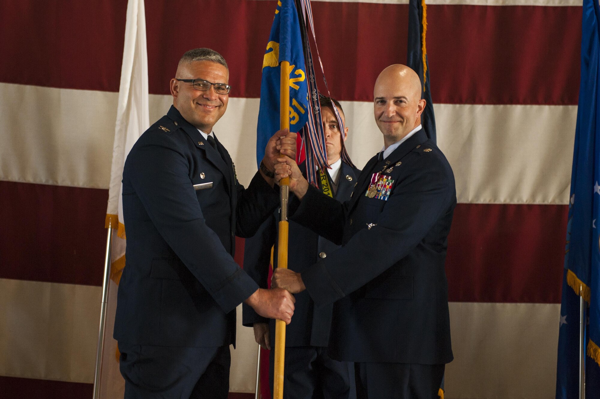 U.S. Air Force Lt. Col. Matthew Welling, prior 312th Training Squadron Commander, passes the unit guideon to Col. Alejandro Ganster, 17th Training Group Commander, during the 312th TRS change of command at the Louis F. Garland Department of Defense Fire Academy High Bay Fire Academy high bay on Goodfellow Air Force Base, Texas, July 10, 2017. Welling served as the 316th TRS Commander from 2015 to 2017. (U.S. Air Force photo by Senior Airman Scott Jackson/Released)