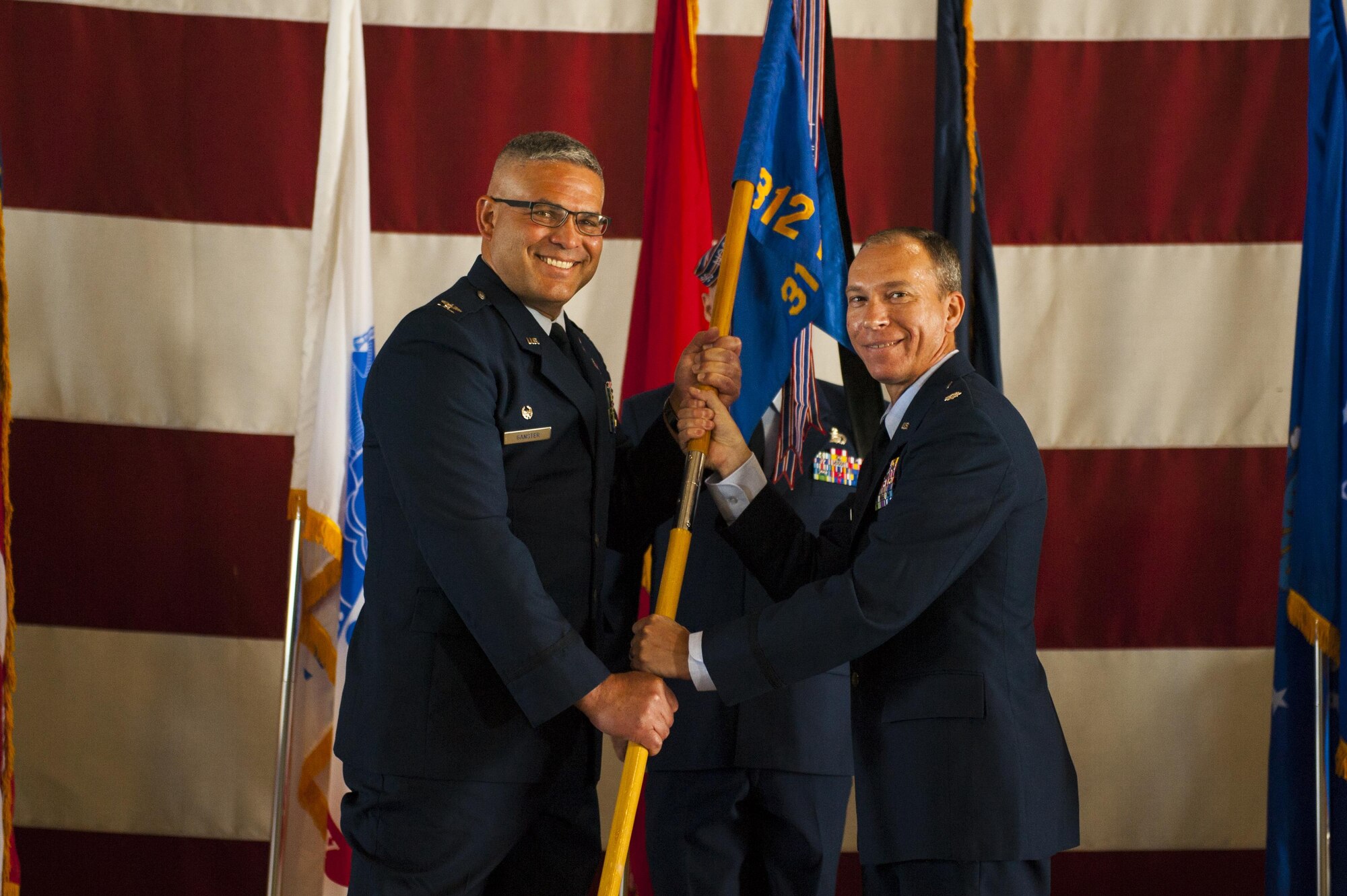 U.S. Air Force Lt. Col. Scott D. Cline, 312th Training Squadron Commander, receives the unit guideon from Col. Alejandro Ganster, 17th Training Group Commander, during the 312th TRS change of command at the Louis F. Garland Department of Defense Fire Academy High Bay Fire Academy high bay on Goodfellow Air Force Base, Texas, July 10, 2017. The change of command ceremony is a time honored military tradition that signifies the orderly transfer of authority. (U.S. Air Force photo by Senior Airman Scott Jackson/Released)