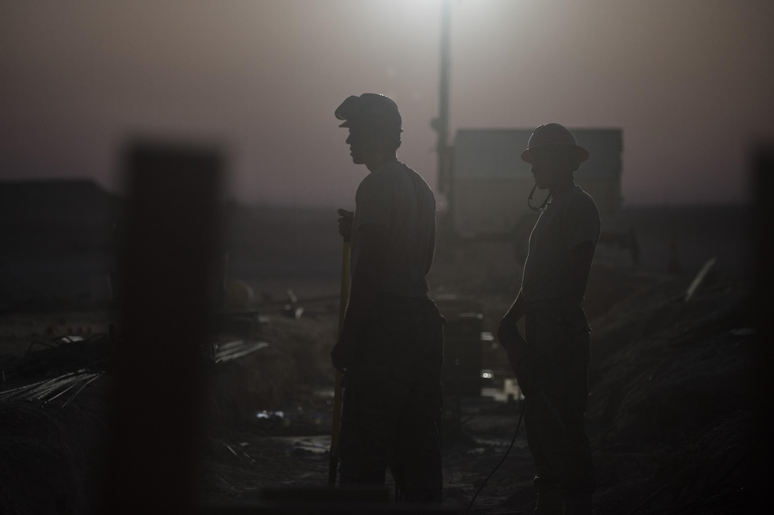 Airmen assigned to the 557th Expeditionary RED HORSE, wait for further instructions while working on a construction site June 27, 2017, in Southwest Asia. The squadron is tasked with constructing a new 332nd Air Expeditionary Wing mission support industrial complex and life support area, to include facilities, utilities and roads, providing the wing with increased capabilities. (U.S. Air Force photo/Senior Airman Damon Kasberg)