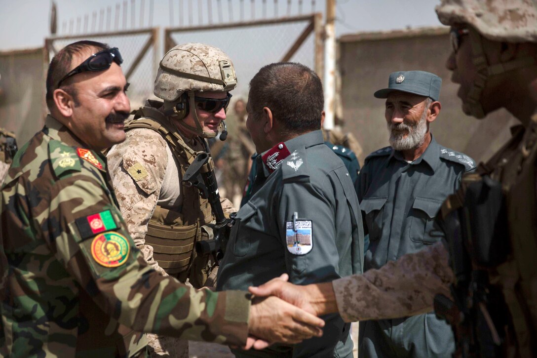 U.S. Marine Corps Brig. Gen. Roger Turner, center left, commander,  Task Force Southwest, and U.S. Marine Corps Col. David Gibbs, right, team police commander, Task Force Southwest, greet their Afghan National Defense and Security Force partners after arriving at the Helmand Provincial Police Headquarters in Lashkar Gah, Afghanistan, July 9, 2017. The visit provided an opportunity for advisors to meet with their counterparts, review the security postures and ensure that Afghan National Defense and Security Forces have an effective defense of Lashkar Gah. Marine Corps photo by Sgt. Justin T. Updegraff