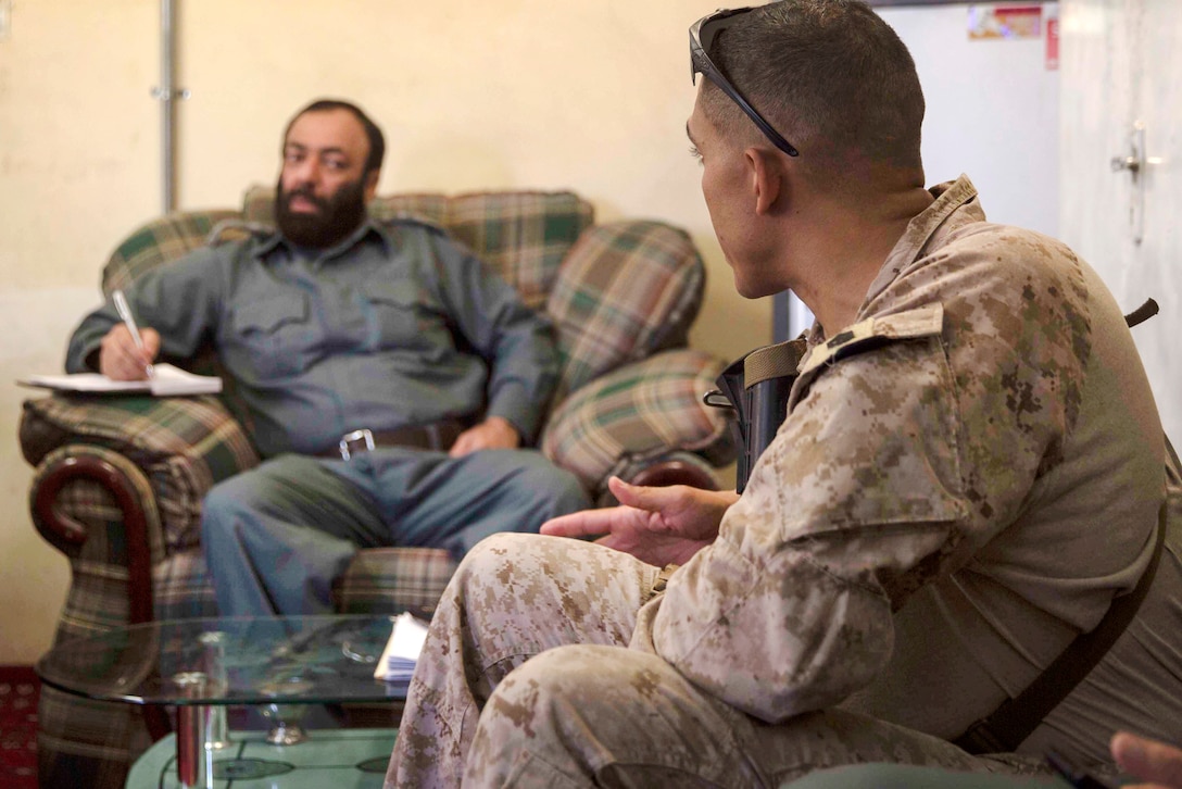 A U.S. Marine, right, speaks with his counterpart during a train, advise and assist mission at the Helmand Provincial Police Headquarters in Lashkar Gah, Afghanistan, July 9, 2017. Marine Corps photo by Sgt. Justin T. Updegraff