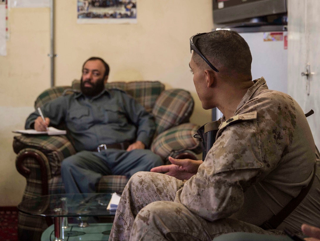 A U.S. Marine advisor with Task Force Southwest speaks with his counterpart during a train, advise and assist mission at the Helmand Provincial Police Headquarters in Lashkar Gah, Afghanistan, July 9, 2017. This mission provided an opportunity for advisors to meet with their counterparts, review the security posture at the PHQ and ensure that Afghan National Defense and Security Forces have an effective defense of Lashkar Gah. (U.S. Marine Corps photo by Sgt. Justin T. Updegraff)