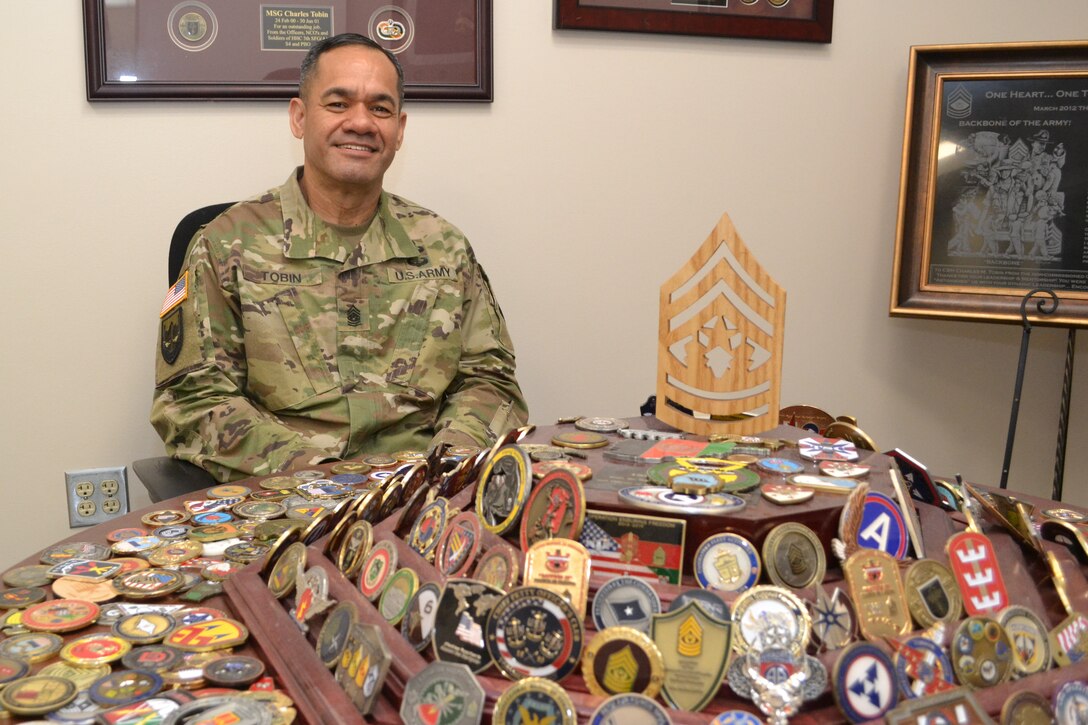 DLA Senior Enlisted Leader Command Sgt. Maj. Charles Tobin displays his collection of challenge coins. 