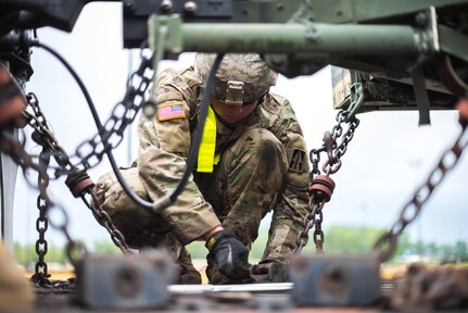 An Indiana National Guard member fastens and inspects equipment being loaded onto the railcar at Camp Atterbury, Ind. on July 6, 2017. Guard members from Indiana, Illinois and Pennsylvania joined together in support of Task Force Hoosier to assist the 76th Infantry Brigade Combat Team in transporting their equipment to Fort Polk, La. for an upcoming Joint Readiness Training Center Rotation. 