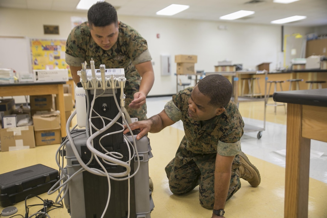 Petty Officer 2nd Class John Lagmay (left) and Petty Officer 3rd Class Gabriel Adjetey (right), dental corpsmen with 4th Dental Battalion, 4th Marine Logistics Group, Marine Forces Reserve, check the air pressure on equipment that will be used to provide dental care during Innovative Readiness Training Louisiana Care 2017 at East Saint John High School in Reserve, Louisiana on July 11, 2017. The Louisiana Care Innovative Readiness Training event is a joint-service medical mission that provides the military with “hands-on” readiness training opportunities, while at the same time providing direct and lasting benefits to the residents of Louisiana. (Photo by U.S. Marine Pvt. Samantha Schwoch/Released.)