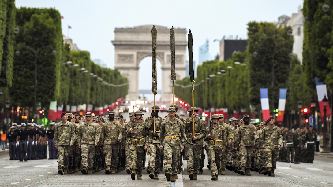 Almost 200 U.S. soldiers, sailors, Marines and airmen march from the Arc de Triomphe in Paris.