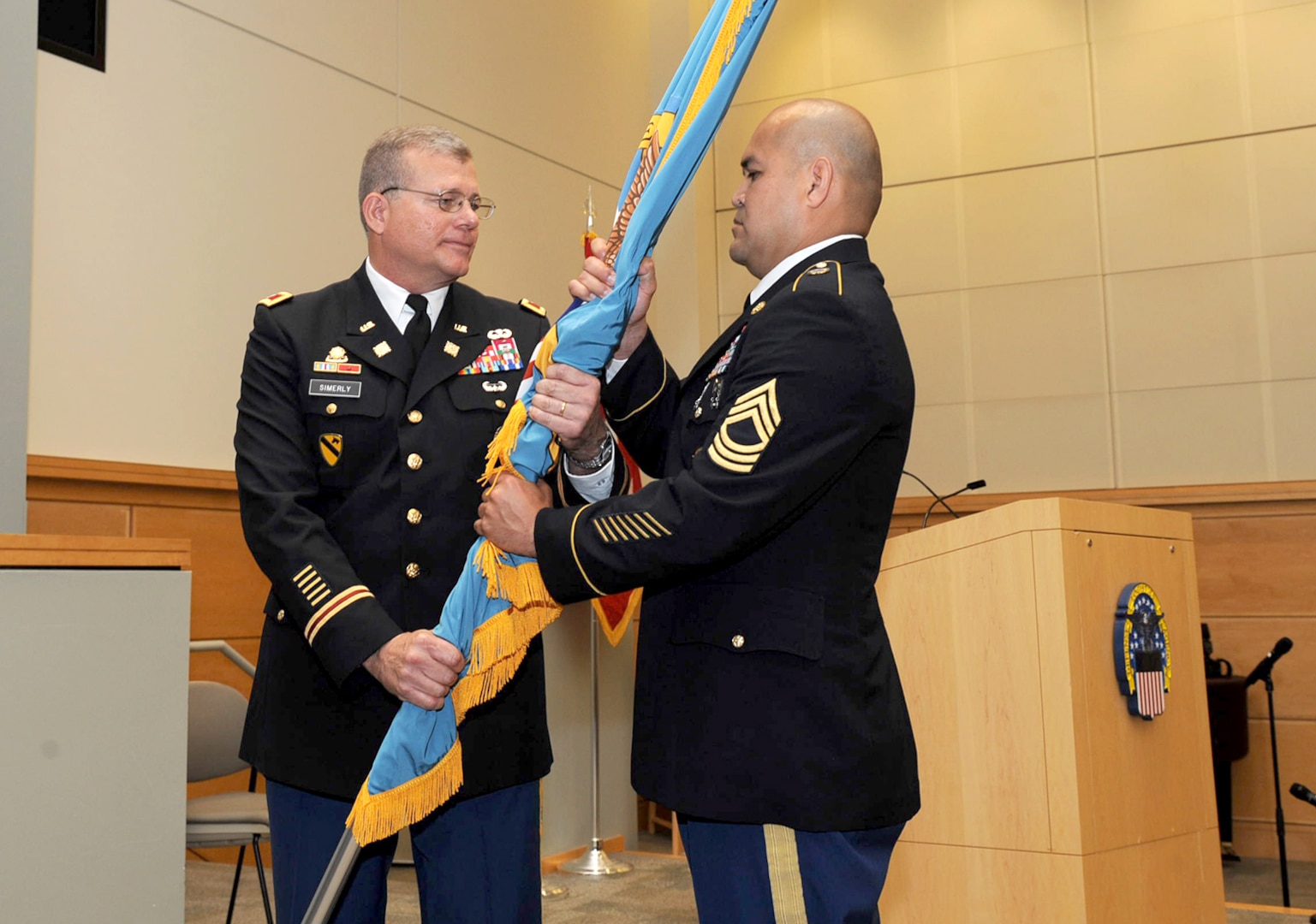 Army Col. Mark Simerly, DLA Troop Support incoming commander, passes the DLA flag to Army Master Sgt. Jose Moraga, DLA Troop Support senior enlisted service member, during a change of command ceremony July 11 in Philadelphia. Simerly was previously the director of capabilities, development and integration with the Combined Arms Support Command at Fort Lee, Virginia. 