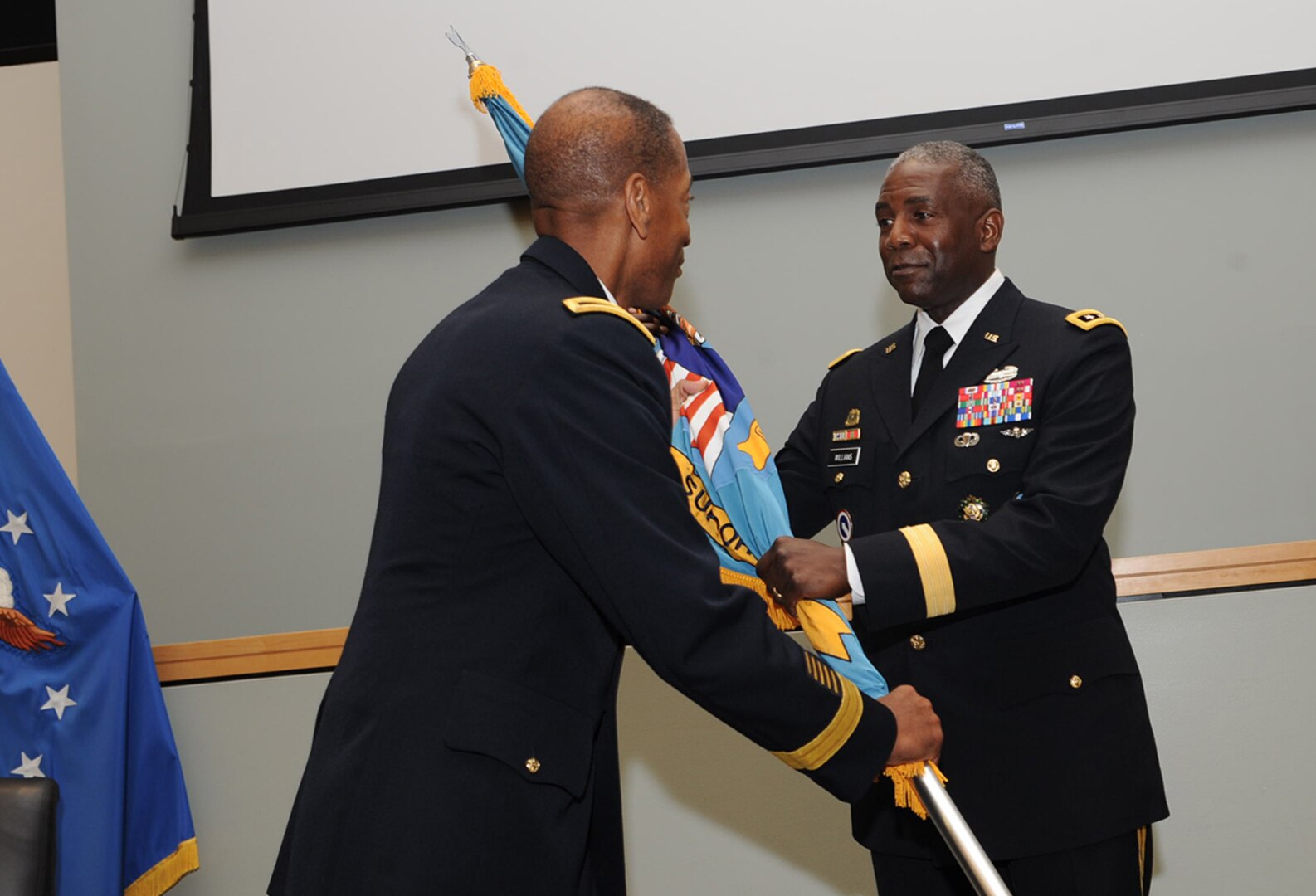 Army Brig. Gen. Charles Hamilton passes the DLA flag to Army Lt. Gen. Darrell Williams, DLA director, as he relinquishes command of DLA Troop Support to Army Col. Mark Simerly during a change of command ceremony July 11. Hamilton will become the senior military logistician at U.S. Forces Korea. 