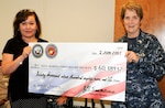 Rear Adm. Rebecca McCormick-Boyle (right), commander, Navy Medicine Education, Training and Logistics Command presents Angelica Botkin, Navy Marine Corps Relief Society director of the San Antonio office, with a check representing the money collected by Navy and Marine Corps commands in the San Antonio area during an annual fund drive. NMETLC was one of several commands to contribute and McCormick-Boyle presented the check as the senior Navy officer in the San Antonio area.