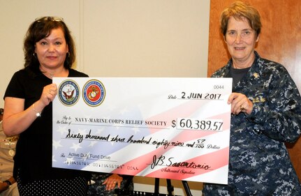 Rear Adm. Rebecca McCormick-Boyle (right), commander, Navy Medicine Education, Training and Logistics Command presents Angelica Botkin, Navy Marine Corps Relief Society director of the San Antonio office, with a check representing the money collected by Navy and Marine Corps commands in the San Antonio area during an annual fund drive. NMETLC was one of several commands to contribute and McCormick-Boyle presented the check as the senior Navy officer in the San Antonio area.