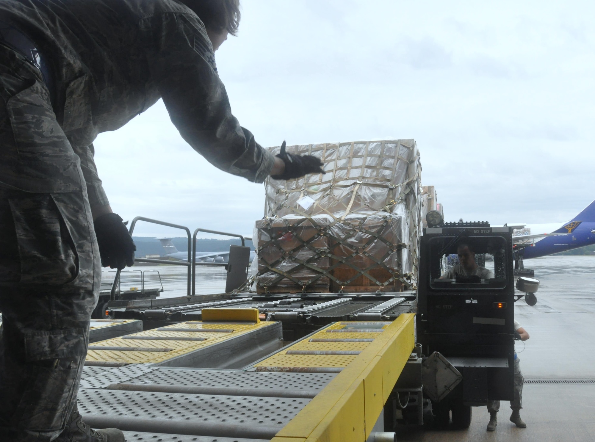 Staff Sgt. Darla Tokarski of the Wisconsin Air National Guard's 128th Logistics Readiness Squadron guides into position the 60K cargo handler driven by Staff Sgt. Tyler Cross, Air Transportation Specialist with the 81st Aerial Port Squadron out of Joint Base Charleston, S.C., at Ramstein AB, Germany, July 12, 2017.  Citizen Airmen of the 128th LRS and 81st APS performed two weeks of annual training at Ramstein in order to maintain readiness and familiarization with high-volume aerial port operations.  (U.S. Air Force photo by 1st Lt. Justin Clark)